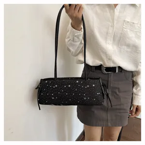 Detail shot of a black shoulder bag with star pattern, casual baguette style worn by model.