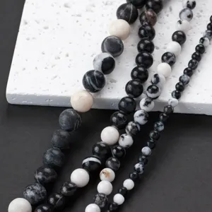 Close-up of black and white natural stone round beads, ideal for DIY jewelry making.