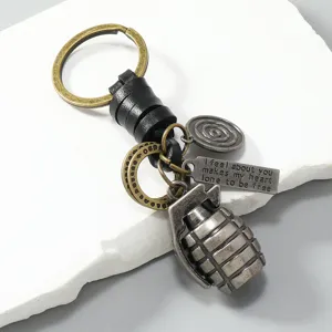 Vintage metalen granaatsleutelhanger met gevlochten leren koord voor heren in retro stijl.