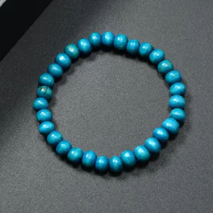 Primer plano detalle de pulsera de cuentas de madera azul, textura lisa y diseño.