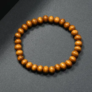 Primer plano de pulsera de cuentas de madera con textura redonda lisa y cuerda elástica.
