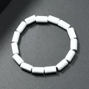 Detalle de pulsera de cuentas de madera cilindricas blancas,joyeria vintage minimalista.
