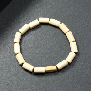 Primer plano detalle de la pulsera de cuentas de madera cilindrica minimalista y textura.