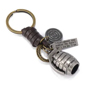 Vintage metalen granaat sleutelhanger met lederen koord, stijlvol accessoire voor heren.