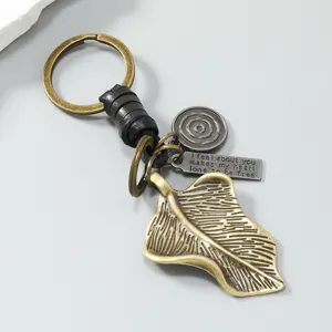 Gedetailleerd overzicht van retro metalen bladsleutelhanger met gevlochten leer en label.