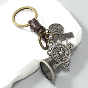 Vintage metal keychain detail showing horn, gears and leather cord pendants close-up.