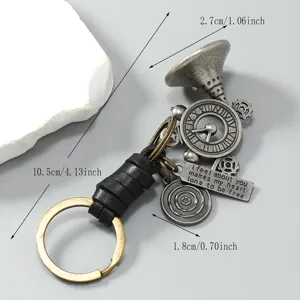 Vintage metal horn and clock gear keychain detail view with genuine leather braided strap.