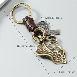 Gedetailleerd overzicht van vintage metalen bladsleutelhanger met leren gevlochten touw.