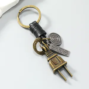 Detailed shot of retro metal plug keychain with leather strap and engraved metal pendant.