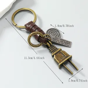 Detailed view of the vintage metal plug keychain with leather braid and engraved tag.