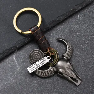 Llavero de metal con cabeza de toro vintage, cuerda de cuero trenzada y placa grabada.