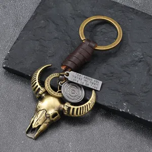 Llavero vintage de metal con cabeza de toro y cuerda de cuero trenzado para hombre.