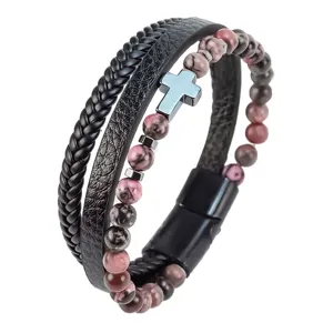 Primer plano detallado de la pulsera de cuero multicapa con cuentas y cruz de metal.