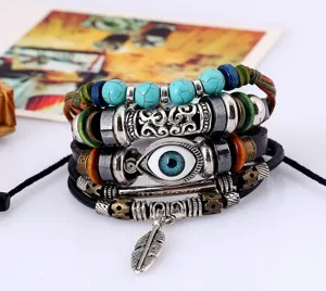 Détail en gros plan d'un ensemble de bracelets en cuir vintage multicouche avec perles et breloque.