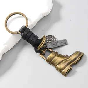 Vintage leather braided boot keychain detail, bronze alloy pendant charm display.