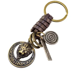 Porte-clés tête de lion vintage avec lanière en cuir de vache, anneau et pendentifs.