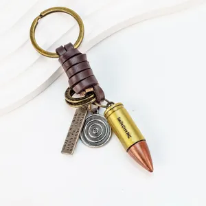 Detailed view of the vintage bullet keychain with leather wrap, metal charms and engraved quote.