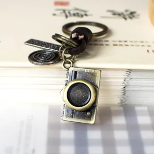Bonito llavero vintage retro de cámara colgante de metal con cordón de cuero detalles.