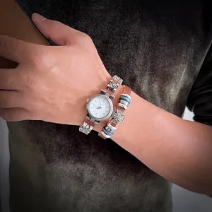 Gros plan sur montre en cuir vintage et bracelet croix, accessoires poignet style punk rock.