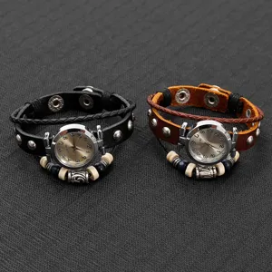 Detalle de primer plano de reloj de pulsera vintage de cuero con correa trenzada y abalorios.