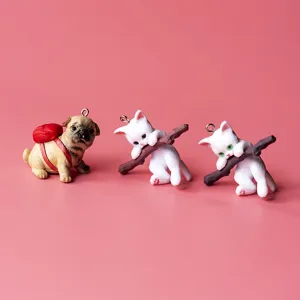 Cute resin animal charms detail shot featuring a pug and white cats hanging pendants.