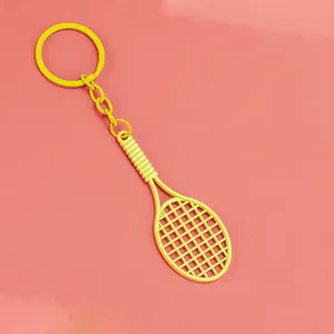 Vista detallada del llavero de raqueta de tenis amarilla, accesorio de bolso compacto.