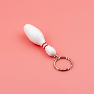 Mini white bowling pin keychain with red stripes, cute sports souvenir and metal ring accessory.
