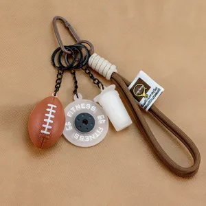 Cute football keychain sports bag charm with wrist strap and dumbbell pendant detail view.