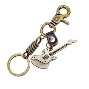 Vintage brons metalen gitaar sleutelhanger hanger met lederen bandje, creatief tasaccessoire.