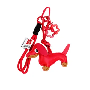 Mignon porte-clés teckel rouge, charm de sac avec lanière tressée, mousqueton métallique et fleurs.