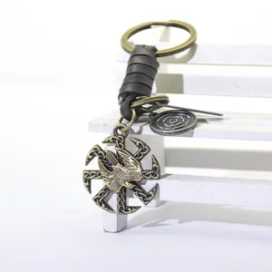 Porte-clés en alliage bronze vintage avec corde en cuir tressé et pendentif oiseau.
