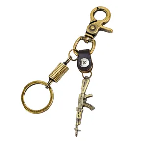 Detailed shot of vintage bronze alloy rifle keychain, featuring miniature gun pendant and brass ring.