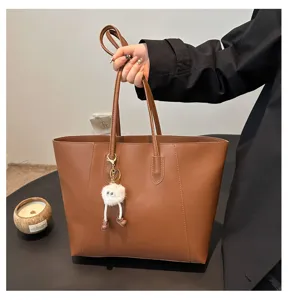 Grand sac cabas marron en cuir PU avec charmant pendentif peluche, sac bandoulière chic.