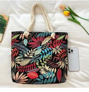 Leaf print canvas beach bag detail showing large capacity, cotton rope handles and fabric style.