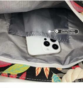 Canvas beach bag interior detail view showing grey lining, zipper, and patch pocket.