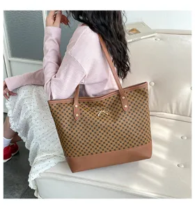 Λεπτομέρεια κομψής καφέ τσάντας shopper με γεωμετρικό μοτίβο, χρυσό φιόγκο και ευρύχωρο εσωτερικό.