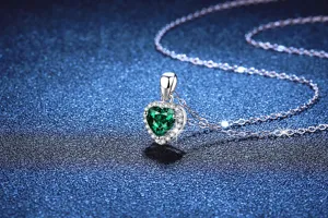 Close-up detail of silver heart emerald pendant necklace with sparkling cubic zirconia stones.