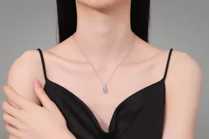 Close-up of sterling silver emerald-cut gemstone necklace on neck, detailed jewelry shot.