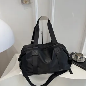 Detailed view of black lightweight travel duffel bag, showing durable fabric and sturdy straps.