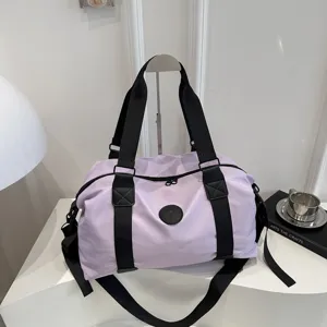 Lightweight purple travel duffel bag detail, featuring durable black straps and spacious interior storage.