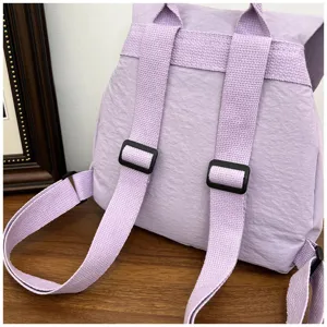Gros plan détaillé des bretelles de sac à dos violet clair et des boucles en plastique.