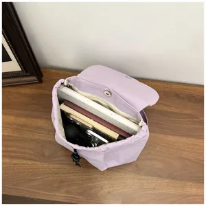 Vue détaillée du mini sac à dos violet, montrant la capacité intérieure et le cordon.