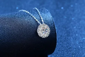 Close-up detail of sparkling sunflower moissanite pendant necklace, elegant silver clavicle chain.