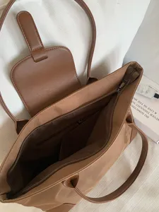 Detailed view of brown nylon tote bag with zipper closure and interior compartments.