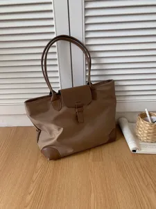 Brown nylon tote bag detail view, large capacity commuting handbag with shoulder straps for women.