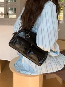 Chic black patent leather shoulder bag featuring dual front pockets for modern women daily use.