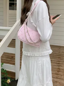 Pink quilted baguette bag detail, bow pattern design with pearl and metal chain straps.