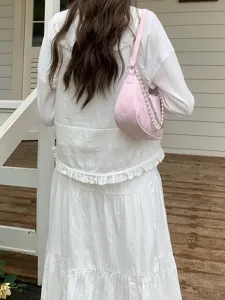 Stylish pink quilted baguette shoulder bag featuring elegant pearl and metal chain details.