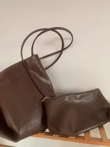 Brown slouchy tote bag detail, soft leather shoulder bag with matching pouch for women daily.
