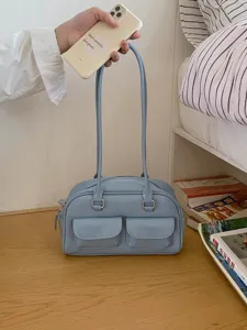 Retro style blue shoulder bag detail showing double front pockets and smooth zipper closure.
